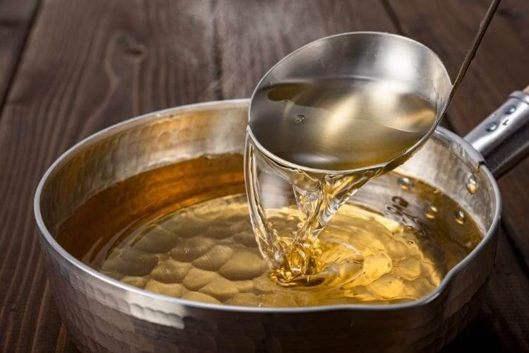 鍋からおたまですくわれる黄金色の出汁